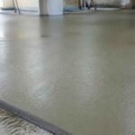 Gładka, świeżo wylana szara posadzka betonowa we wnętrzu budynku